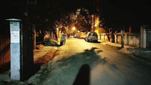Road by illuminated city at night