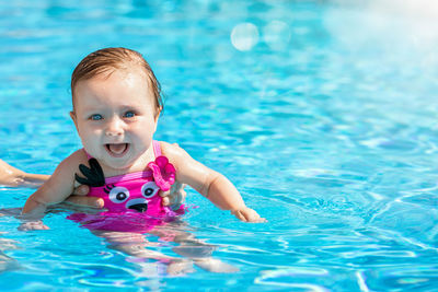 Portrait of cute baby girl in swimming pool