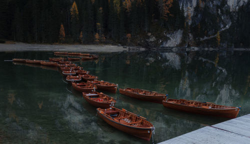 Boats moored on river by trees