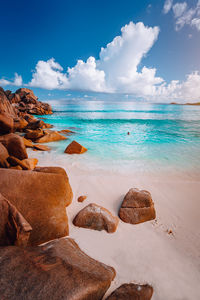 Scenic view of rocks on beach against sky