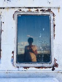 Woman reflecting on window of boat