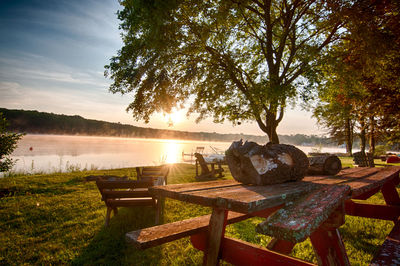 Scenic view of table by lake against sky during sunset