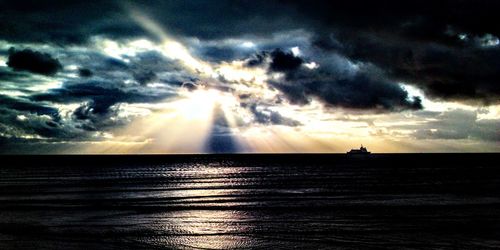 Scenic view of sea against dramatic sky during sunset