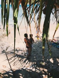 Full length of woman carrying daughter at beach