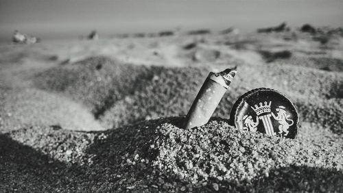 Close-up of cigarette butt on sand