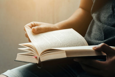 Midsection of woman reading book