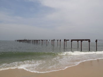 Abandoned pier over sea against sky