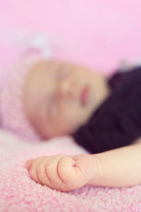 Close-up of baby sleeping on bed