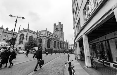 People walking on street amidst buildings in city