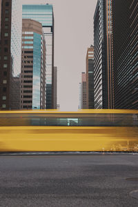 Blurred motion of bus against buildings in city