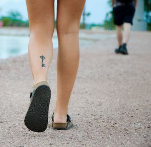 Low section of woman walking at beach