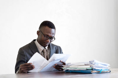 Young man wearing mask on table against white background