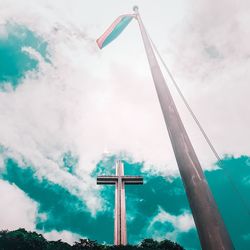 Low angle view of cross on pole against sky