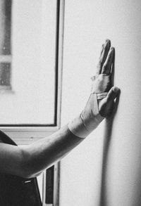 Cropped hand of woman gesturing against wall