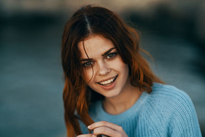 Portrait of smiling young woman in blue sweater