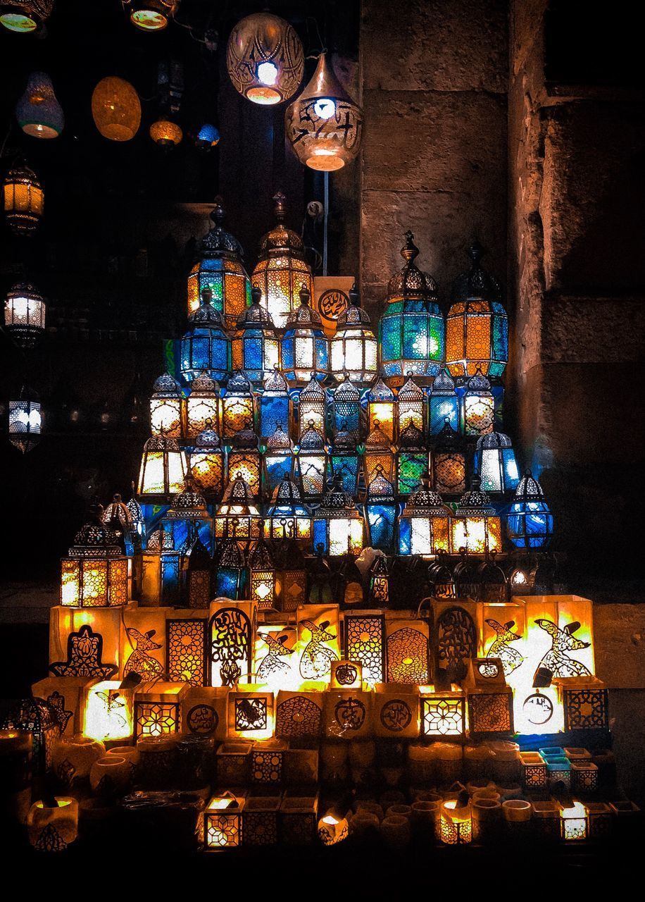 LOW ANGLE VIEW OF ILLUMINATED LANTERNS HANGING IN BUILDING