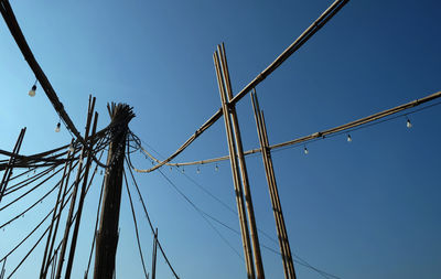 Low angle view of cables against clear blue sky