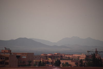 Town by mountains against clear sky at dusk