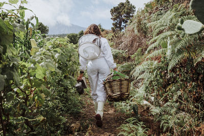 Young woman beekeeper at work in a nature