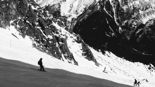 Man skiing on snowcapped mountain against sky