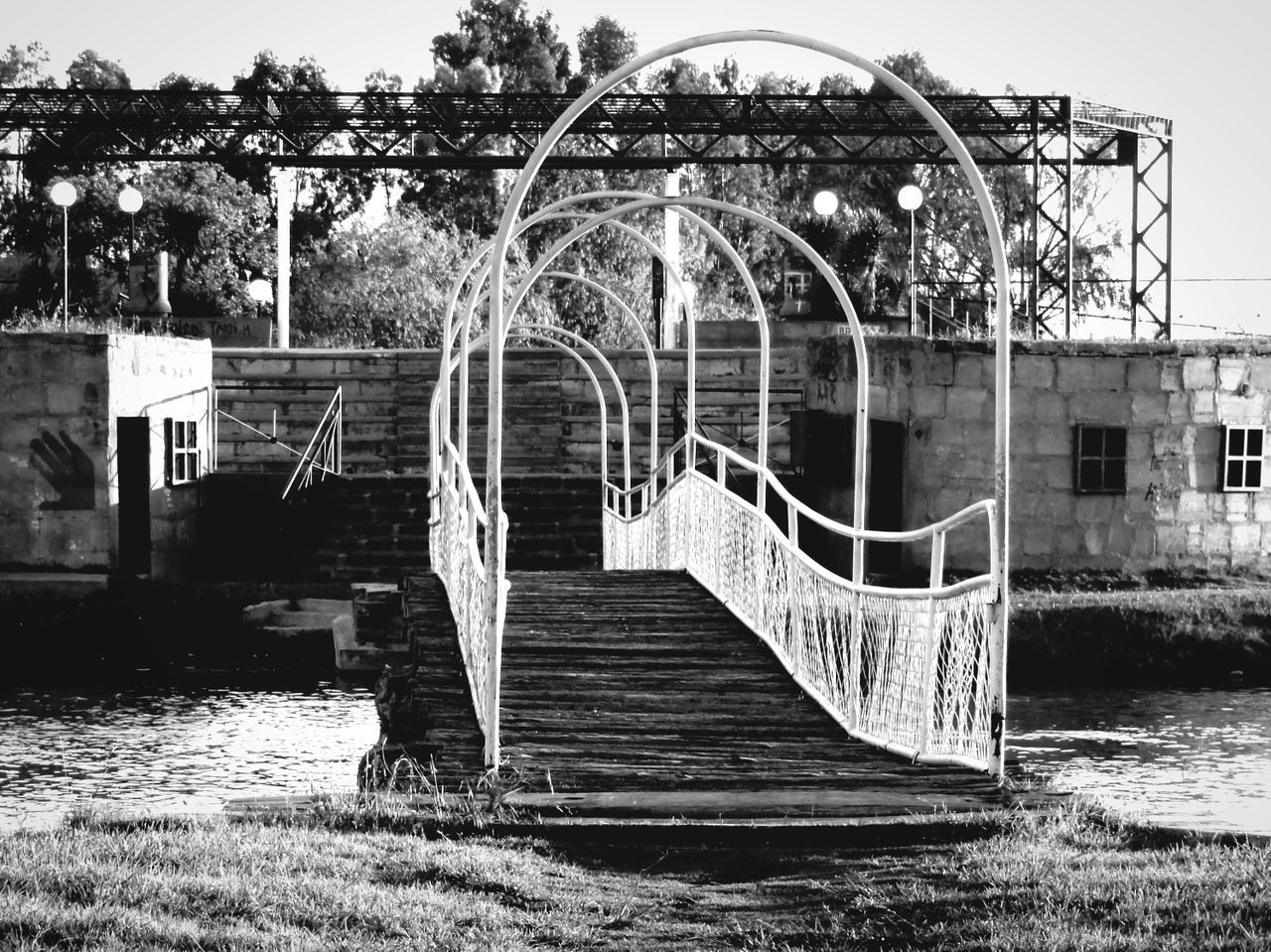 built structure, architecture, building exterior, railing, clear sky, tree, day, water, metal, no people, outdoors, steps, river, absence, wood - material, staircase, metallic, nature, sunlight, art