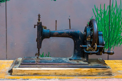 Close-up of old machine part against wall