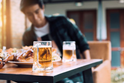 Midsection of man using mobile phone while sitting on table