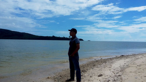 Full length of man standing on beach against sky