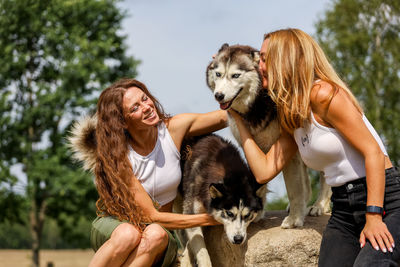 Dog and woman with dogs on tree against trees