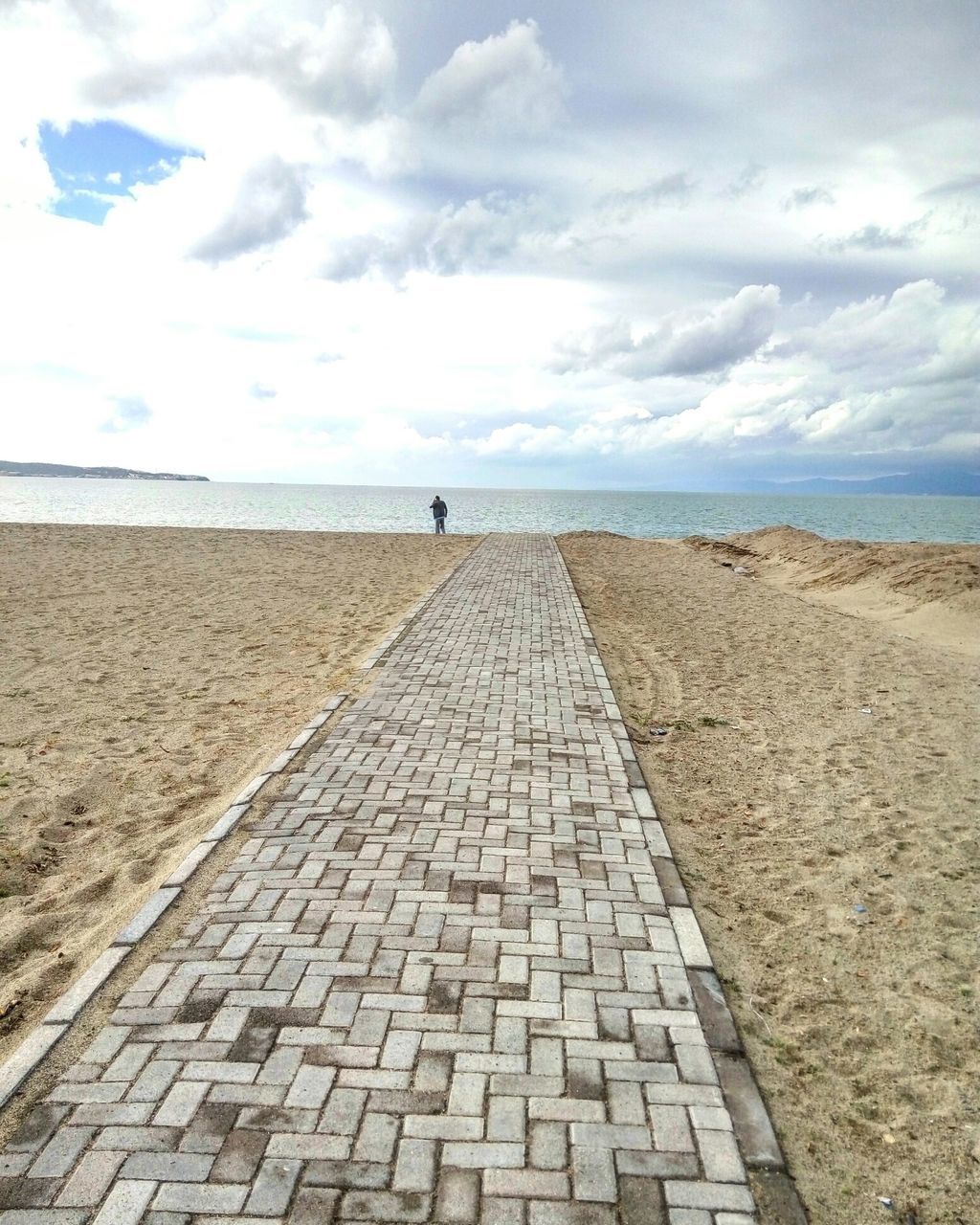 sky, cloud - sky, sea, the way forward, horizon over water, beach, cloud, cloudy, tranquility, tranquil scene, water, sand, cobblestone, day, diminishing perspective, scenics, nature, shore, outdoors, footpath