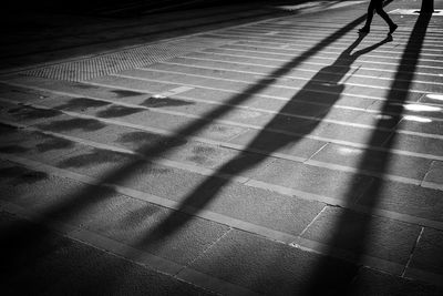 Shadow of person walking on footpath