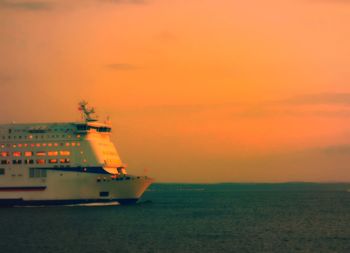 Boat in sea at sunset