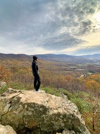 Rear view of man looking at mountain against sky