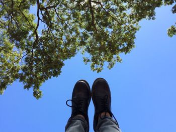 Low section of man against blue sky