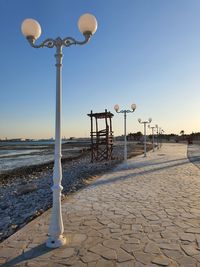 Street light on beach against clear sky