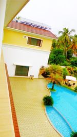 House and swimming pool by building against clear sky