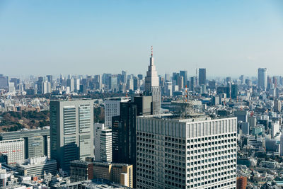 Aerial view of buildings in city against clear sky