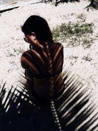 Close-up of young woman sitting on sand