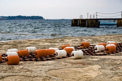 Close-up of buoys at beach against clear sky