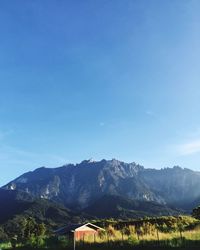 Scenic view of mountains against blue sky