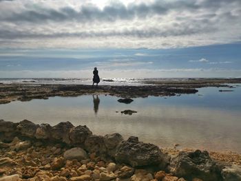 Scenic view of rocks on beach against sky