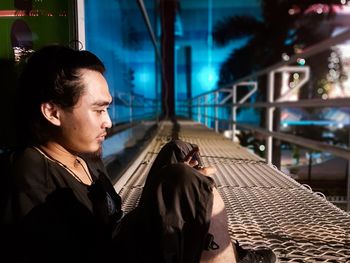 Man sitting at balcony and using mobile phone