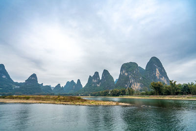 Scenic view of lake by mountains against sky