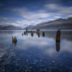 Scenic view of lake and mountains against cloudy sky