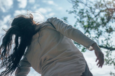 Woman dancing against sky