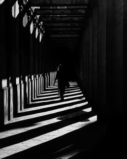 Rear view of woman walking in corridor of building