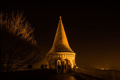 Low angle view of illuminated building against sky at night