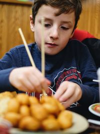 Close-up of boy sitting on table