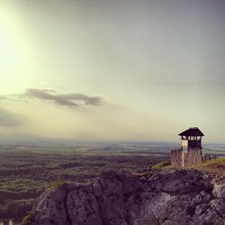 Lighthouse on hill against sky