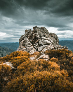 Rock formation against cloudy sky